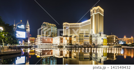 Night view of Venetian buildings in Cotai, Macau, with beautiful reflections of the majestic buildings in the water, owned by the American Las Vegas Sands company. Night view of Venetian buildings in Cotai, Macau, with beautiful reflections of the majestic buildings in the water, owned by the American Las Vegas Sands company. 141549432