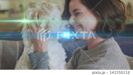 Cradling woman grey knit sweater bringing noses close on couch, holding small white dog, lens flare Cradling woman grey knit sweater bringing noses close on couch, holding small white dog, lens flare 141550118