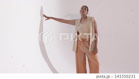 Posing woman touching wall with left-arm in studio, beige blazer, rust pants, halftone, copy space Posing woman touching wall with left-arm in studio, beige blazer, rust pants, halftone, copy space 141550231