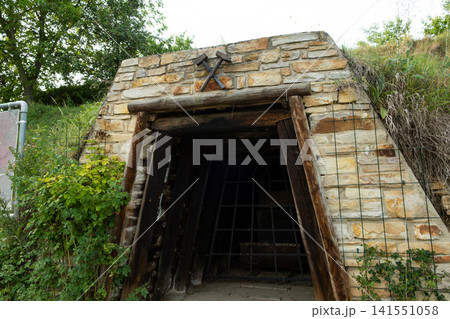 Entrance to an old mine shaft built with stone wall and wooden beams 141551058