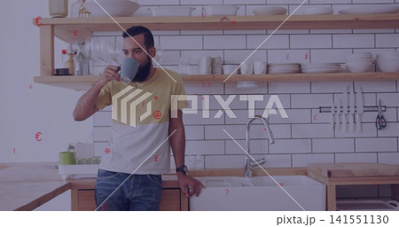Drinking man in yellow-striped tee and jeans leaning on counter in home kitchen, holding grey mug Drinking man in yellow-striped tee and jeans leaning on counter in home kitchen, holding grey mug 141551130