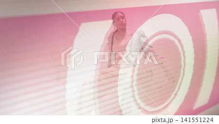 Posing adult woman wearing sleeveless top and open jacket in studio, showing circular projection Posing adult woman wearing sleeveless top and open jacket in studio, showing circular projection 141551224