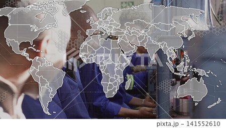 Operating control panels, factory team in blue work shirts handling parts under world map overlay 141552610
