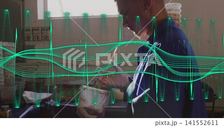 Stirring worker in blue shirt at workshop bench holding white tub, tool, green waveform, copy space 141552611