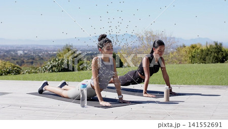 Exercising two women in sportswear lifting torsos on wooden deck, on black mats with water bottles Exercising two women in sportswear lifting torsos on wooden deck, on black mats with water bottles 141552691