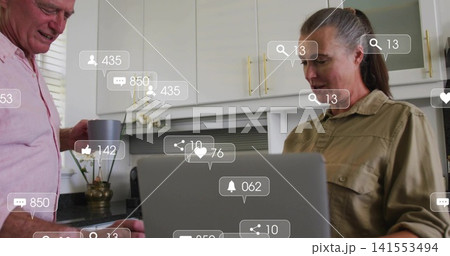 Leaning senior man, woman checking laptop at kitchen counter with gray mug, social overlays, orchid Leaning senior man, woman checking laptop at kitchen counter with gray mug, social overlays, orchid 141553494