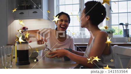 Pouring casually-clad women adding milk from pitcher into bowl at kitchen, French press gold-stars Pouring casually-clad women adding milk from pitcher into bowl at kitchen, French press gold-stars 141553564