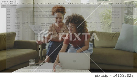 Leaning women checking code on silver laptop at home, wearing short sleeves, with terminal overlay 141553828
