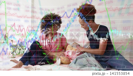 Sitting women wearing pink shirt, dark tee and jeans, cradling wrapped doll on bed, market charts Sitting women wearing pink shirt, dark tee and jeans, cradling wrapped doll on bed, market charts 141553854