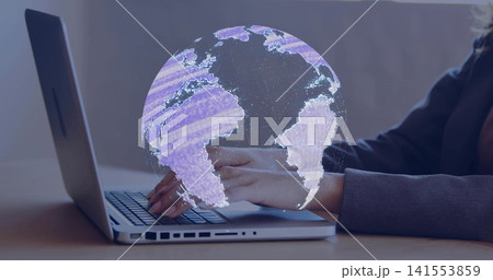 Typing worker in dark blazer using silver laptop with left ports at office desk, projecting globe Typing worker in dark blazer using silver laptop with left ports at office desk, projecting globe 141553859