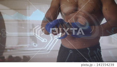 Gripping blue handles, shirtless man training at gym with dark shorts, HUD and dumbbells 141554239