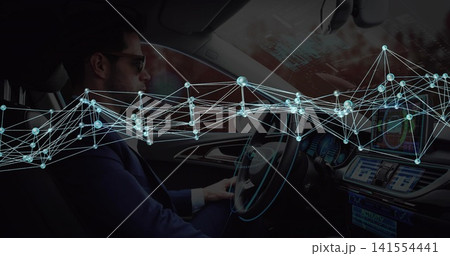 Sitting midadult driver in suit with shades holding wheel in cabin with touchscreen-AR, copy space 141554441