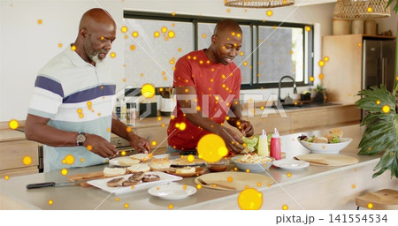 Preparing two men in striped polo and red tee assembling burgers at island, smartphone nearby Preparing two men in striped polo and red tee assembling burgers at island, smartphone nearby 141554534
