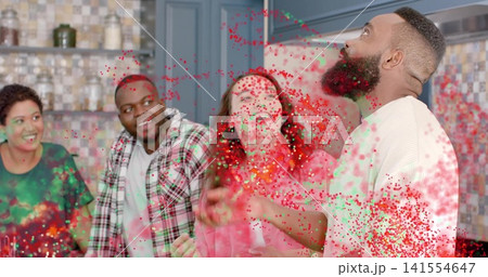 Cheering group of friends watching bearded man throwing colored powder in home kitchen, copy space Cheering group of friends watching bearded man throwing colored powder in home kitchen, copy space 141554647