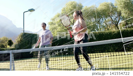 Talking two women near net on grass court with rackets, wearing pink sleeveless top, overlays 141554722