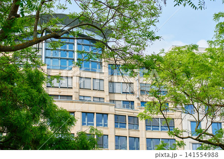 Modern Office Building Surrounded by Green Trees Modern Office Building Surrounded by Green Trees 141554988