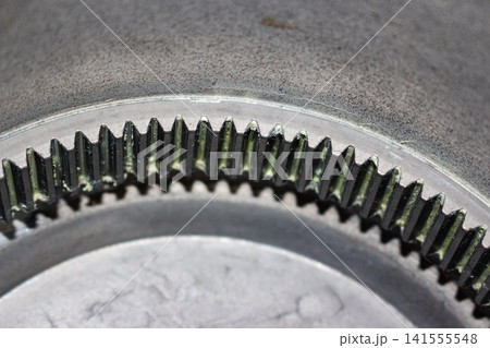 Close-up of a metal ring gear from an electric motor hub, showcasing detailed internal teeth coated with residual thick lubricating grease for smooth mechanical operation Close-up of a metal ring gear from an electric motor hub, showcasing detailed internal teeth coated with residual thick lubricating grease for smooth mechanical operation 141555548