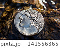 Ancient Greek coin with portrait on obverse washed by water, souvenir replica of ancient coin 141556365