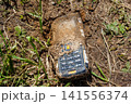 Old push-button telephone that has been lying in the ground for a long time 141556374