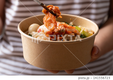 Instant noodle soup with kimchi, bok choy, champignon mushroom, quail egg and Tteokbokki Instant noodle soup with kimchi, bok choy, champignon mushroom, quail egg and Tteokbokki 141556723
