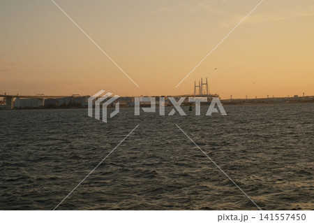 夕焼けの光に包まれた海と港の風景 141557450