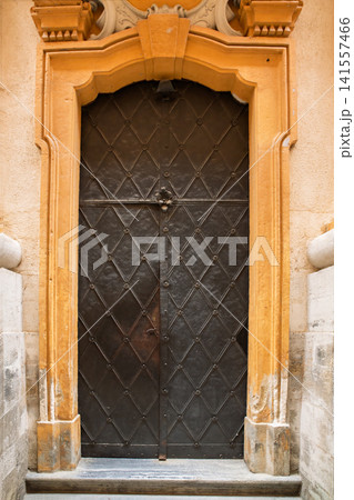 Historic iron door with decorative frame in classic European architecture Historic iron door with decorative frame in classic European architecture 141557466