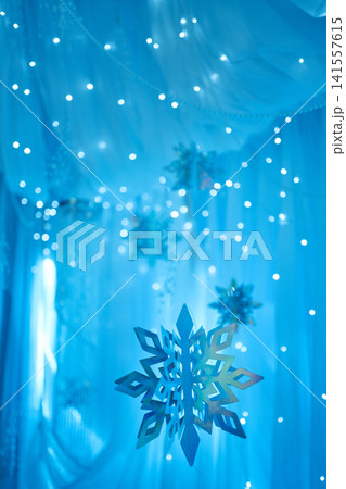 Hanging Metallic Snowflakes on Glowing Blue Bokeh Background Hanging Metallic Snowflakes on Glowing Blue Bokeh Background 141557615