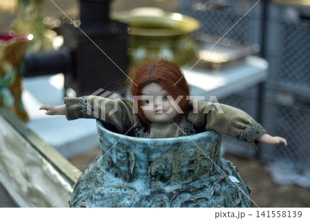 Beautiful retro porcelain doll displayed among vintage objects at a flea market, capturing a nostalgic atmosphere with antique decoration and childhood memories. Beautiful retro porcelain doll displayed among vintage objects at a flea market, capturing a nostalgic atmosphere with antique decoration and childhood memories. 141558139