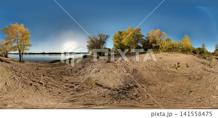 Panoramic riverside sandy bank with autumn deciduous trees, calm reflective water, clear blue sky and warm golden hour light across peaceful landscape, with river, sandy, bank, HDRI 360 panorama Panoramic riverside sandy bank with autumn deciduous trees, calm reflective water, clear blue sky and warm golden hour light across peaceful landscape, with river, sandy, bank, HDRI 360 panorama 141558475