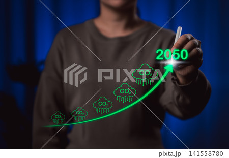 Projected CO2 Reduction Targets by 2050 for Climate Goals. A person draws a rising green arrow with CO2 icons and the year 2050, carbon dioxide reduction efforts and climate change mitigation targets. Projected CO2 Reduction Targets by 2050 for Climate Goals. A person draws a rising green arrow with CO2 icons and the year 2050, carbon dioxide reduction efforts and climate change mitigation targets. 141558780