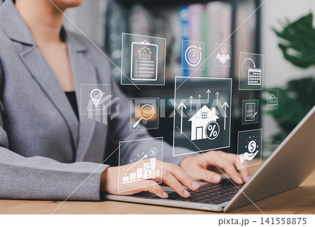 Real estate investment and housing market analysis concept. Businesswoman using laptop and visual data graphics for property growth, mortgage rate, asset management, home buying and sale strategy. Real estate investment and housing market analysis concept. Businesswoman using laptop and visual data graphics for property growth, mortgage rate, asset management, home buying and sale strategy. 141558875