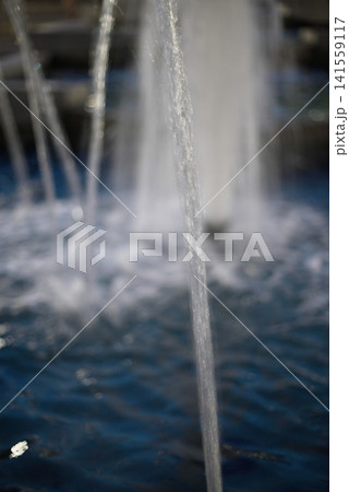 Close view of water streams in a blue fountain Close view of water streams in a blue fountain 141559117