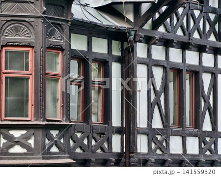 Close-up of timber-framed building facade with sash windows 141559320