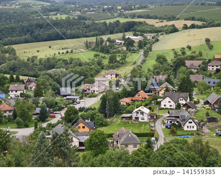 Hillside village with scattered houses and green farmland 141559385