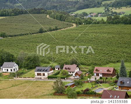 Rural hillside village with houses and fields 141559386