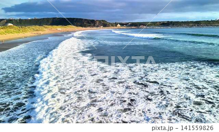 Experience the breathtaking scenic coastal waves at sunset along a beautiful sandy beach 141559826