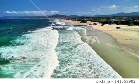 Stunning Aerial Views Showcasing a Serene Beach with Gentle Waves and Clear Blue Skies Stunning Aerial Views Showcasing a Serene Beach with Gentle Waves and Clear Blue Skies 141559902