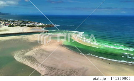 Enjoy a Stunning Aerial View of a Serene Beach and the Colorful, Vibrant Ocean Waves 141559903