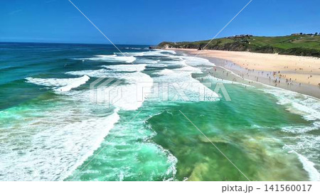 Experience a stunning aerial view of the serene beach and gentle waves on the shore Experience a stunning aerial view of the serene beach and gentle waves on the shore 141560017