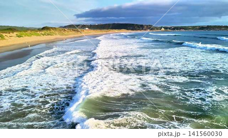 Breathtaking Scenic Views of Waves and Shoreline at Sunset Time on a Beautiful Beach 141560030