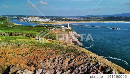 A stunningly beautiful scenic coastal view featuring a lighthouse alongside a marina A stunningly beautiful scenic coastal view featuring a lighthouse alongside a marina 141560096