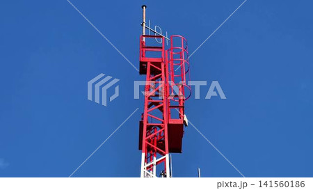 A Telecommunication Tower Standing Tall Against a Clear Blue Sky in the Background A Telecommunication Tower Standing Tall Against a Clear Blue Sky in the Background 141560186