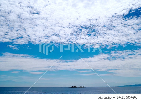 青空と白い雲、小さな島が浮かぶ穏やかな海の風景 青空と白い雲、小さな島が浮かぶ穏やかな海の風景 141560496