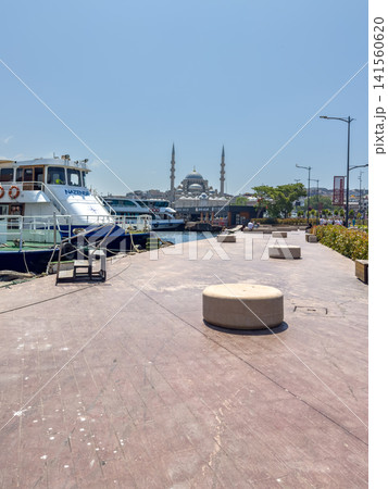 Scenic waterfront view of boats docked along promenade with mosque in background, Istanbul 141560620