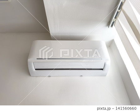Wall-mounted air conditioning unit installed in modern indoor setting Wall-mounted air conditioning unit installed in modern indoor setting 141560660