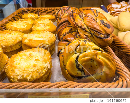 Braided buns and cheesecakes displayed in a wicker basket Braided buns and cheesecakes displayed in a wicker basket 141560673