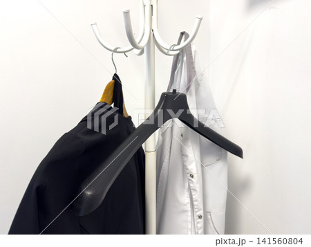 Clothes on hangers in a minimalist setting with a white background 141560804