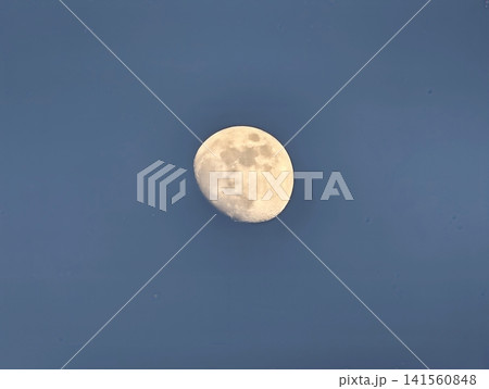 Lunar glow closeup. Gibbous moon illuminated by gentle light reveals textured surface clearly Lunar glow closeup. Gibbous moon illuminated by gentle light reveals textured surface clearly 141560848