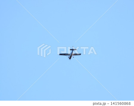 Quiet sky flight. An individual pilot navigates small aircraft through serene sky dotted with few clouds 141560868