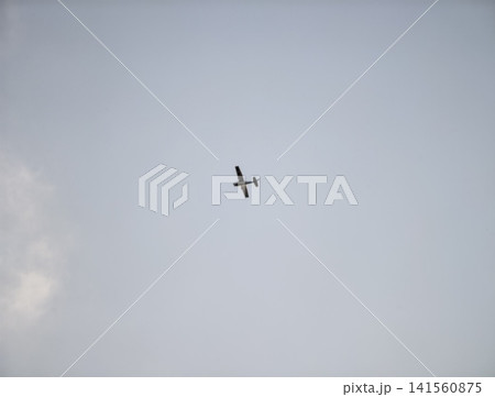 Skyline framed by gentle sunlight. Bright afternoon with single plane drifting softly above tranquil waters Skyline framed by gentle sunlight. Bright afternoon with single plane drifting softly above tranquil waters 141560875
